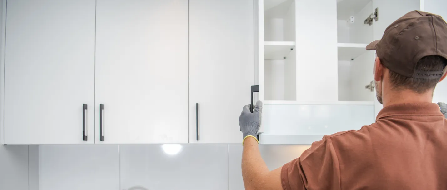 Contractor installing modern kitchen cabinets during kitchen remodeling project